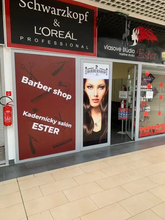 Polep výkladu kaderníckeho salónu Ester s tlačenou grafikou a označením vlasového štúdia